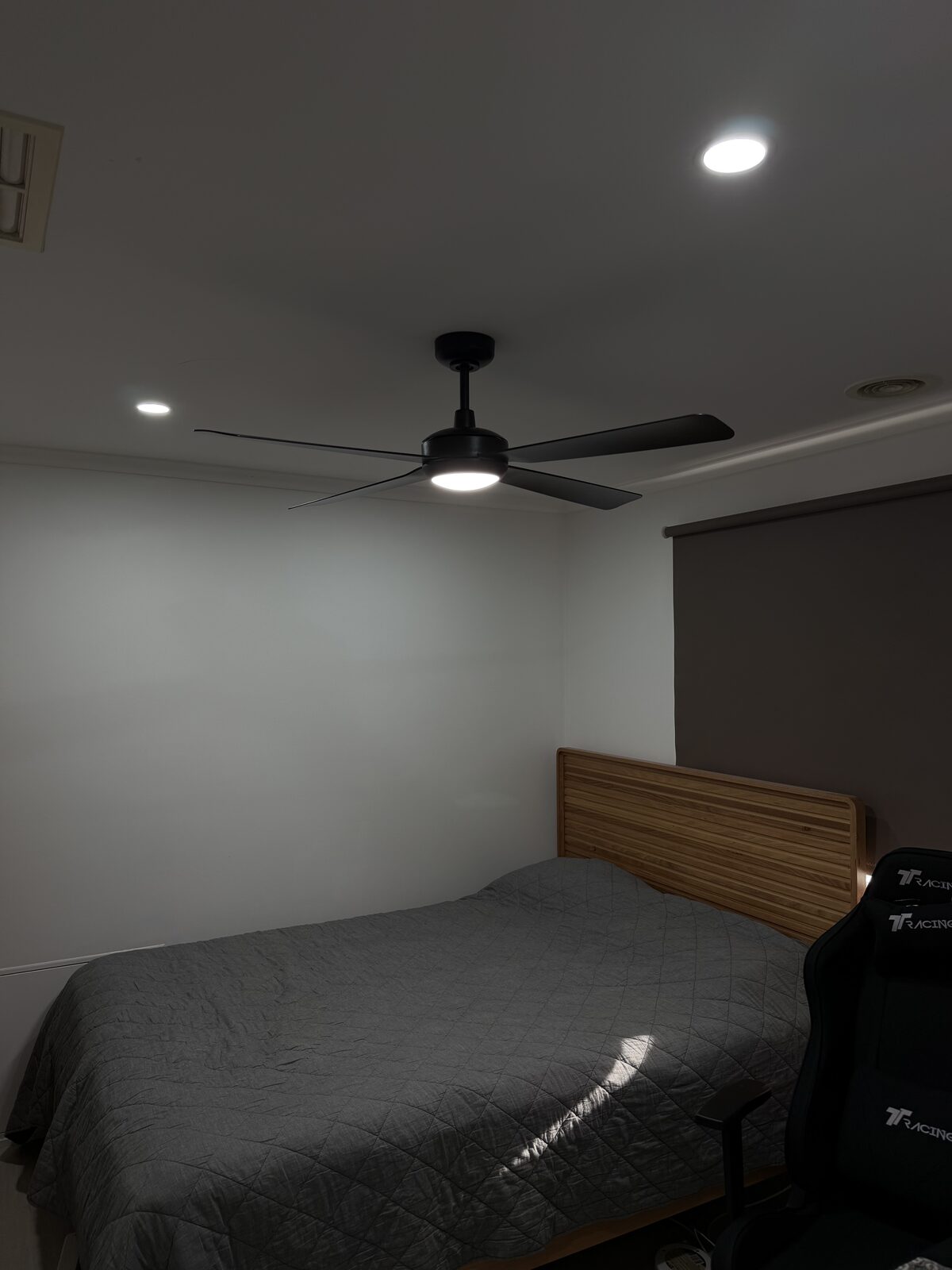 Black ceiling fan with light installed in a bedroom