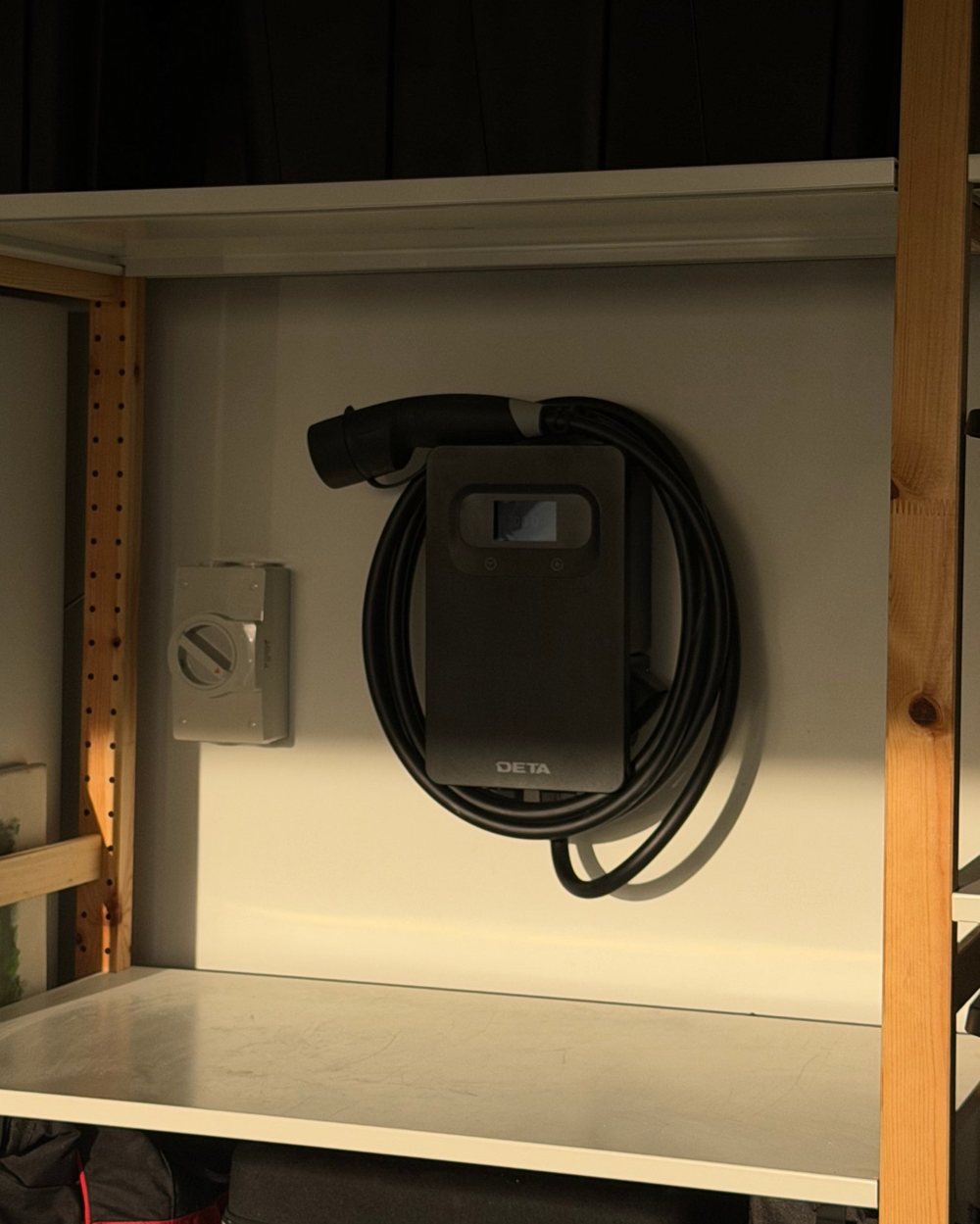 DETA EV charger wall unit with charging cable mounted in a garage