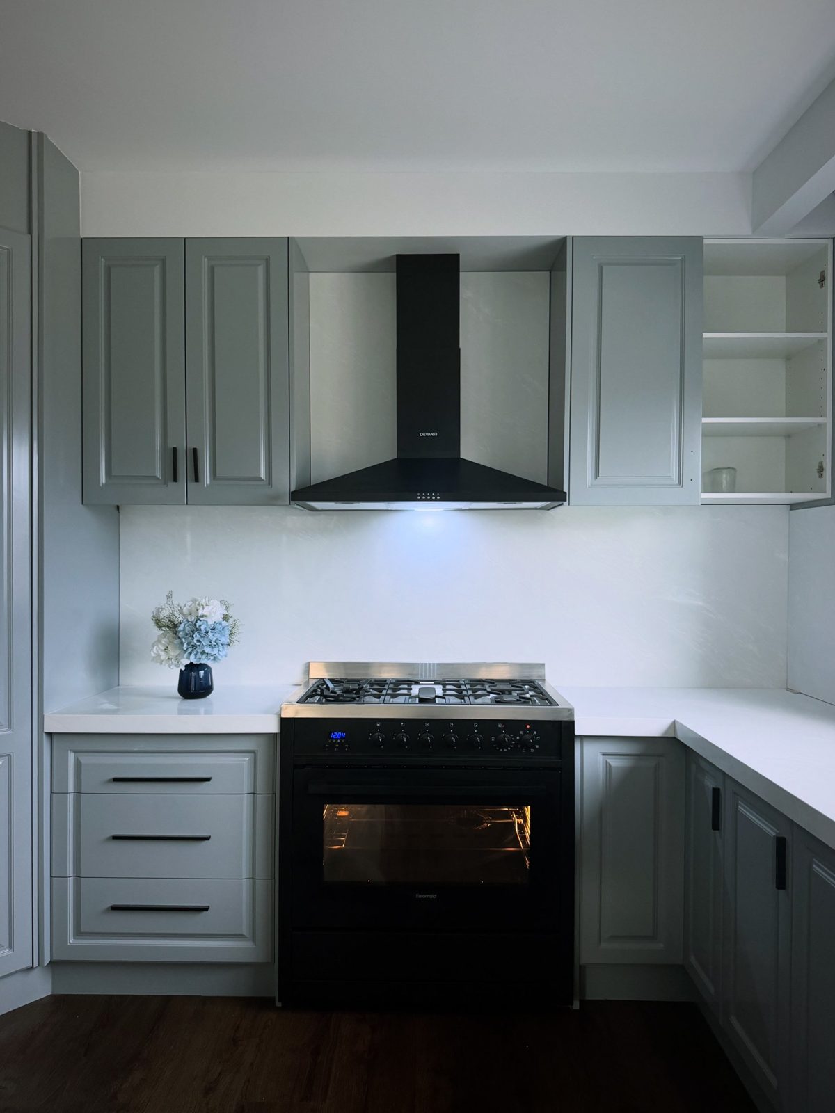 New kitchen with black freestanding oven and cooktop and black rangehood