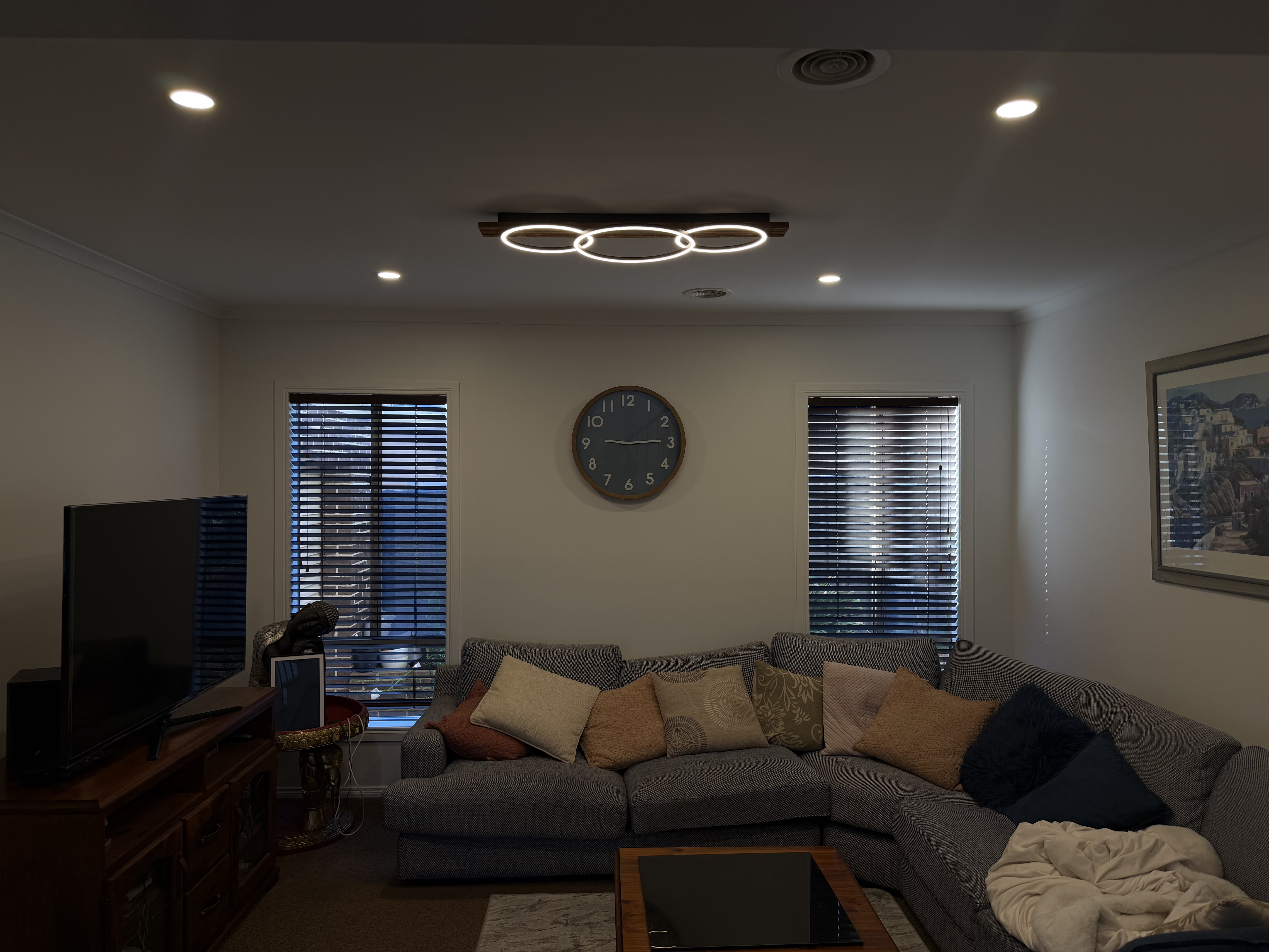 Ring-style ceiling light and downlights installed in a living room